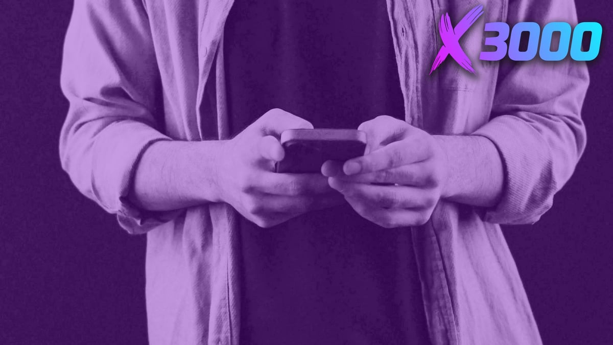 En man står med sin mobiltelefon och aktiverar sin X3000 casino bonus.